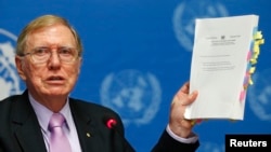 Michael Kirby, Chairperson of the Commission of Inquiry on Human Rights in North Korea holds a copy of his report during a news conference at the United Nations in Geneva on February 17, 2014.