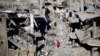 Anak-anak Palestina berjalan di antara rumah-rumah yang hancur akibat serangan Israel di tengah gencatan senjata sementara antara Israel dan Hamas, di kamp pengungsi Khan Younis, di selatan Jalur Gaza, 29 November 2023. (Foto: REUTERS/Mohammed Salem)