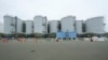 FILE - A black pipeline runs along tanks containing treated radioactive wastewater at the Fukushima nuclear power plant in Futaba town, Japan, July 14, 2023. 