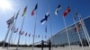 FILE - Finnish military personnel install the Finnish national flag at the NATO headquarters in Brussels, on April 4, 2023.