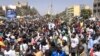 FILE - Civil society groups and political groups hold placards as they march calling on authorities respect the election date, in Dakar, on Feb. 17, 2024.