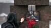 A woman touches a photo of Alexey Navalny after laying flowers at the Memorial to Victims of Political Repression in St. Petersburg, Russia, on Feb. 17, 2024.
