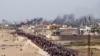 Sejumlah warga Palestina tampak berbaris menanti truk bantuan untuk lewat ke wilayah mereka di bagian tengah Jalur Gaza, pada 19 Mei 2024. (Foto: AP/Abdel Kareem Hana)