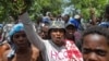 Residents of the neighborhood Carrefour Feuilles gather outside a military base demanding help after they had to flee their homes when gangs took over, in Port-au-Prince, Haiti Aug. 16, 2023. 