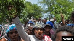 FILE — Residents of the neighborhood Carrefour Feuilles gather outside a military base demanding help after they had to flee their homes when gangs took over, in Port-au-Prince, Haiti Aug. 16, 2023. 