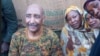A handout image posted on the Sudanese Armed Forces' Facebook page shows army chief General Abdel Fattah al-Burhan posing for a picture with civilians in Khartoum during a tour of a neighborhood in the capital on Aug. 24, 2023. 