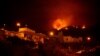 A picture taken in the night of Aug. 19, 2023, shows the fronts of the forest fire on hills above houses, in the Guimar valley on the Canary Island of Tenerife. 