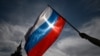 Seorang pria mengibarkan bendera nasional Rusia di pusat kota Moskow pada 11 Juni 2023. (Foto: AFP/Kirill KUDRYAVTSEV)