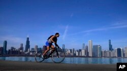 A cyclist pedals around Lake Michigan near the Adler Planetarium, Feb. 26, 2024, in Chicago. 
