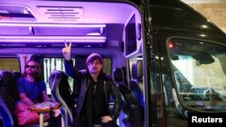 Maksim Andryushchenko dan Igor Bortnik, anggota dari grub band rock Bi-2. duduk di dalam kendaraan setelah tiba di Bandara Internasional Ben Gurion di Lod, Israel, dari Thailand pada 1 Februari 2024. (Foto: Reuters/Tomer Appelbaum)