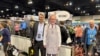 Para pemegang saham Berkshire Hathaway berfoto dengan poster investor dan CEO Warren Buffett dalam rapat pemegang saham tahunan Bershire Hathaway di Omaha, Nebraska, Jumat, 3 Mei 2024. (Foto: Josh Funk/AP Photo)
