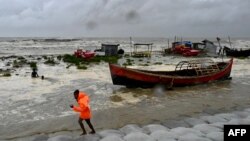 Seorang pria menarik perahu nelayan ke pantai sebagai tindakan pencegahan saat hujan turun di Kuakata, Bangladesh, pada 26 Mei 2024, menjelang datangnya topan Remal. (Foto: AFP)