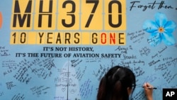 A woman writes a message on the message board during the tenth annual remembrance event at a shopping mall, in Subang Jaya, on the outskirts of Kuala Lumpur, Malaysia, March 3, 2024. 