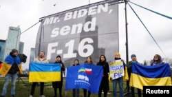Demonstran pro-Ukraina meminta Presiden AS Joe Biden untuk mengirim jet F-16 ke Ukraina, di Warsawa, Polandia, 22 Februari 2023. (Foto: Reuters)