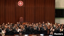 19일 홍콩 입법회에서 새 국가보안법안 가결 직후 의원들과 존 리(앞줄 가운데 오른쪽) 행정장관을 비롯한 관료들이 기념촬영한 뒤 박수하고 있다.