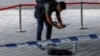 Seorang petugas polisi memotret barang-barang milik tersangka penikaman di Hong Kong, China, 4 Oktober 2023. Dua orang tewas dan 21 lainnya terluka, setelah seorang pria melakukan penikaman di barat daya China pada Selasa (7/6), (Foto: REUTERS/Tyrone Siu)