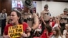 Authorities remove Allison Polidor (left) from a House Civil Justice Hearing for holding a sign during a legislative session in Nashville, Tennessee, to discuss gun violence, Aug. 22, 2023.