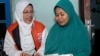 Lingga Permesti, left, a legislative candidate for Indonesia's Islamic Prosperous Justice Party (PKS), presents a calendar to a resident during house visitations ahead of the election in Klaten, Central Java, Jan. 18, 2024.