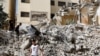 Anak-anak Palestina berjalan di tengah puing-puing bangunan yang rusak akibat serangan Israel di kamp Jenin di Tepi Barat yang diduduki Israel, 23 Mei 2024. (REUTERS /Raneen Sawafta)