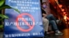 FILE - People are seen at an area of Japanese restaurants where there is a sign reading 'Suspend the sale of all fish products imported from Japan', in Beijing on Aug. 27, 2023. 