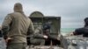 FILE - Servicemen stand near a military vehicle at a defense position, where Ukraine's National Guard prepares to defend Odesa, Apr. 10, 2023. (Ritzau Scanpix/Bo Amstrup via Reuters) 