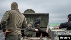 FILE - Servicemen stand near a military vehicle at a defense position, where Ukraine's National Guard prepares to defend Odesa, Apr. 10, 2023. (Ritzau Scanpix/Bo Amstrup via Reuters) 