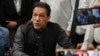 Mantan perdana menteri Pakistan, Imran Khan memberi isyarat setelah tiba di kantor pendaftaran di Pengadilan Tinggi Lahore untuk menandatangani surat jaminan untuk jaminan dalam berbagai kasus, di Lahore pada 3 Juli 2023. (Foto: AFP)