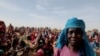 Halime Adam Moussa, seorang pengungsi Sudan, menunggu bersama pengungsi lainnya untuk menerima porsi makanan dari Program Pangan Dunia di Koufroun, Chad, dekat perbatasan antara Sudan dan Chad, 9 Mei 2023.
