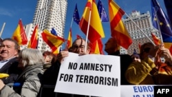 Protestors hold signs and wave Spanish flags during a demonstration called by the opposition party Partido Popular (PP) against the government's amnesty law, on the Plaza de Espana square in Madrid, Jan. 28, 2024.