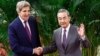 Utusan Iklim AS John Kerry dan Direktur Kantor Komisi Urusan Luar Negeri Komite Sentral Partai Komunis China Wang Yi (kanan) berjabat tangan sebelum pertemuan di Aula Besar Rakyat di Beijing pada 18 Juli 2023. (Foto : AFP)