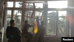 Українські військові встановлюють прапор Україні в Благодатному, Донецької області, відеокадр Єгерської бригади імені Олекси Довбуша, через Reuters