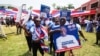 Des partisans tiennent une pancarte représentant Mahamudu Bawumia, vice-président du Ghana et candidat présidentiel du Nouveau Parti patriotique (NPP) pour les élections présidentielles de 2024, à Takoradi, au Ghana, le 18 août 2024.