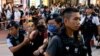 FILE - Polisi Hong Kong menahan seorang perempuan yang membawa bunga kertas di pusat kota pada peringatan 34 tahun penumpasan Lapangan Tiananmen di Beijing tahun 1989.