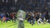 Soccer fans enter the pitch during a clash between supporters at Kanjuruhan Stadium in Malang, East Java, Indonesia, Oct. 1, 2022.