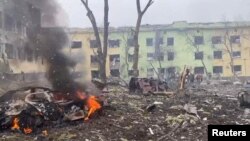 На фото: Атомобілі та будівля лікарні, зруйновані внаслідок авіаційного удару під час вторгнення Росії в Україну
