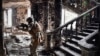 A Russian soldier patrols at the Mariupol drama theater that was bombed last March 16, in Mariupol, as Russian troops intensify a campaign to take the strategic port city, April 12, 2022.
