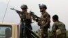 FILE - Afghan military soldiers stand stand alert at the entrance gate of the new parliament building after a rocket attack in Kabul, Afghanistan.