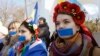 Women with their mouths taped over attend a pro-Ukraine rally in Simferopol, March 13, 2014. 
