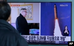 FILE - A man watches a TV news program showing photos published in North Korea's Rodong Sinmun newspaper of North Korea's "Pukguksong-2" missile launch and North Korean leader Kim Jong Un, at Seoul Railway Station in Seoul, South Korea, Feb. 13, 2017.