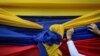 Un partidario de la oposición sostiene una tela con los colores de la bandera venezolana antes de un mitin con el líder opositor Juan Guaidó en el Montalbán de Caracas. Enero 11, 2021.
