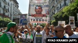 Des manifestants demandent la libération de Karim Tabbou à Alger, le 27 septembre 2019. (Photo by RYAD KRAMDI / AFP)