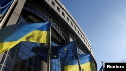 Фото для ілюстрації: прапори ЄС та України поблизу будівлі Європарламенту в Брюсселі. REUTERS/Yves Herman