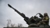A Ukrainian soldier keeps position sitting on a ZU-23-2 anti-aircraft gun at a frontline, northeast of Kyiv, March 3, 2022. 