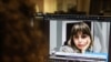 FILE - A woman looks at a screen image of Nazila Maroufian, Nov. 4, 2022. Maroufian, once detained in Iran for coverage of protests, has been rearrested for running afoul of Iran's dress code for women. 