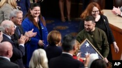 Президент України Володимир Зеленський з прапором, подарованим йому спікеркою Палати представників США Ненсі Пелосі, після промови Зеленського в Конгресі, 21 грудня 2022 року