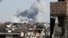 FILE - Smoke rises near a stadium where Islamic State militants were holed up, after an airstrike by coalition forces at the front line in Raqqa, Oct. 12, 2017. 