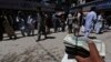 FILE - A money changer holds a stack of U.S. dollars at Kabul's largest money market April 23, 2014. The U.S. has reportedly spent $113 billion rebuilding Afghanistan, more than it spent rebuilding Europe after World War II, adjusted for inflation.