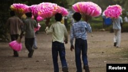 Vendors hold bags of cotton candy for sale as they look for customers in New Delhi on June 28, 2012. India's food inflation rose to 10.66 percent in May from 10.18 percent in April, latest figures show.