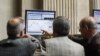 Traders look at a computer screen at the Madrid Bourse, July 24, 2012. 