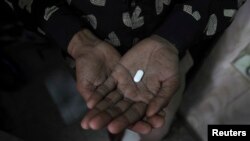 Bệnh nhân nhiễm AIDS tại Ấn Ðộ cầm một viên thuốc chống nhiễm trùng.